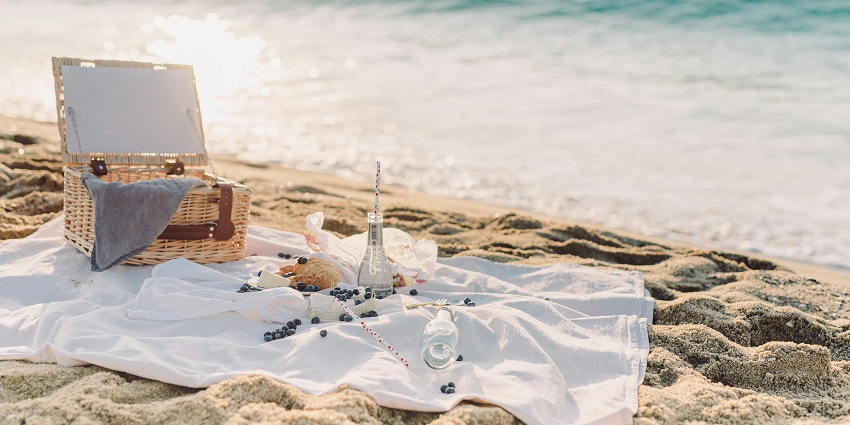 A blanket spread on the sandy shore of a beach similar to one in Madh Island, where you can relax all day.