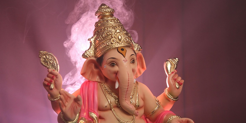 A picture of a tall Ganesha Idol with beautiful lighting, enhancing the view and ambience