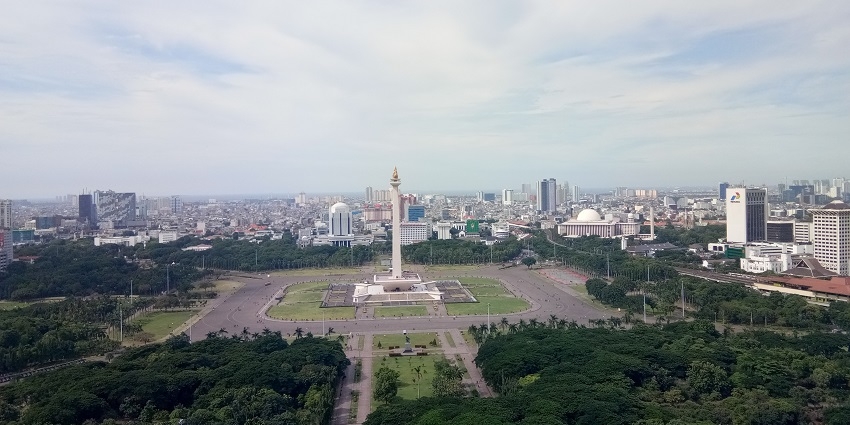 Enjoying a beautiful sky view of Jakarta’s National Monument with buildings around Indonesia, one of the wonderful things to do in Indonesia.
