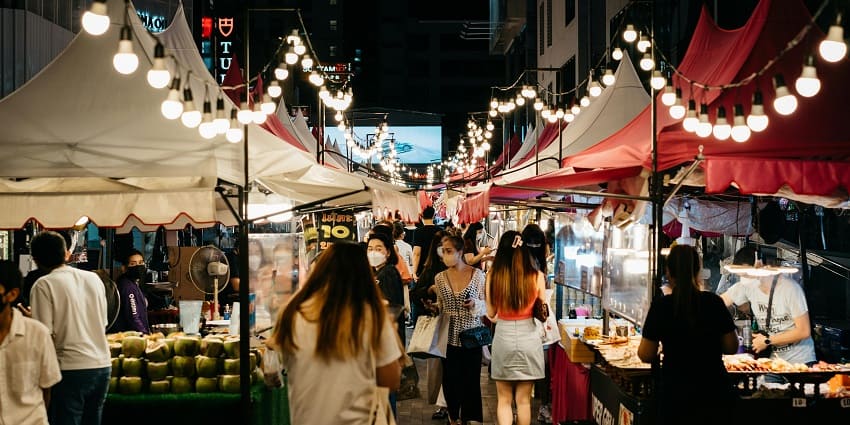 A bustling shopping scene along Hundred Feet Road, Indiranagar, with vibrant stores and cafes