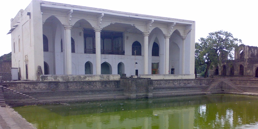 Capture the beauty of Asar Mahal's front view, complemented by a tranquil artificial pond.