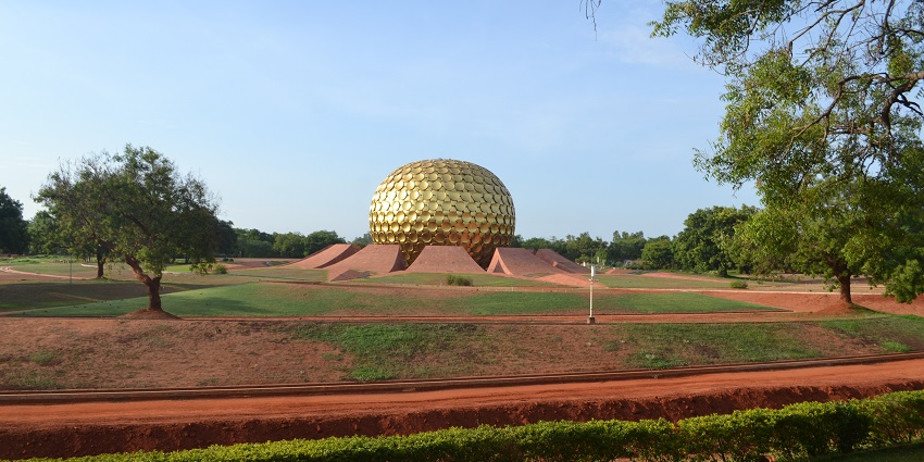 An image of the serene Matrimandir in Auroville, surrounded by lush greenery