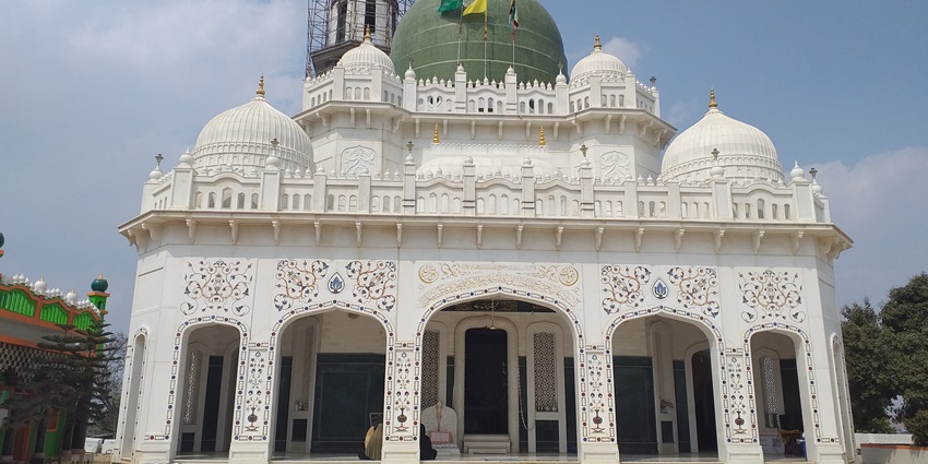 Entrance of a Islamic dargah featuring intricate arches and traditional architectural details