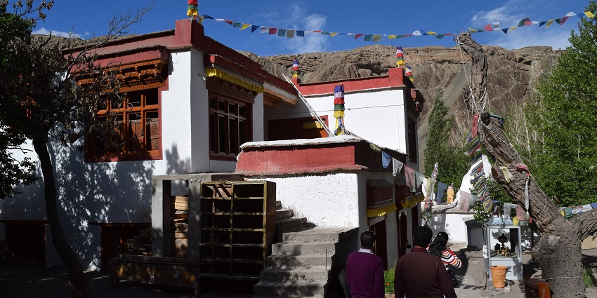 A picture of a traditional monastery in Ladakh with worshippers moving towards the entrance