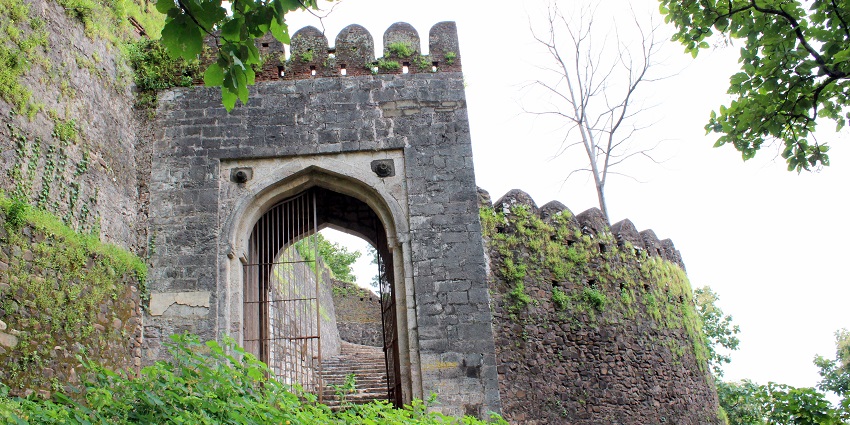 Front view of Khazana at Deogarh Fort, surrounded by similar ruins and greenery.