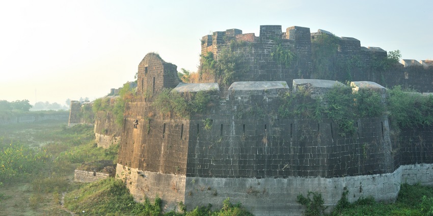 The ancient Kandhar Fort in Maharashtra, with its stone walls, arched entrance, and surrounding dry landscape.