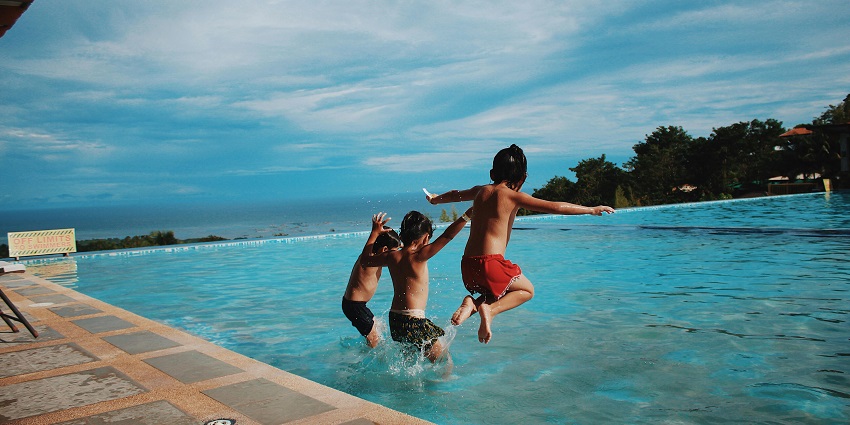 A shot of three guys jumping in the pool during a pool party in Jaipur.