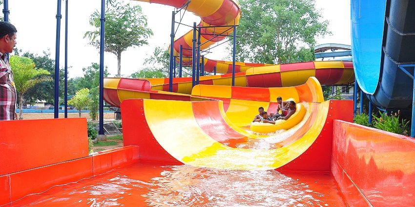 Families enjoying water rides and attractions at Fantasy Water Park on a sunny day