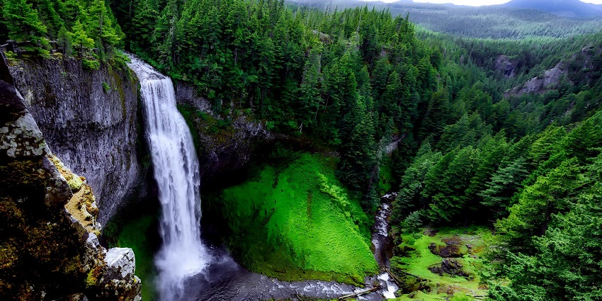 An image of waterfalls flowing over cliffs and one of the top places to visit in Courtallam.