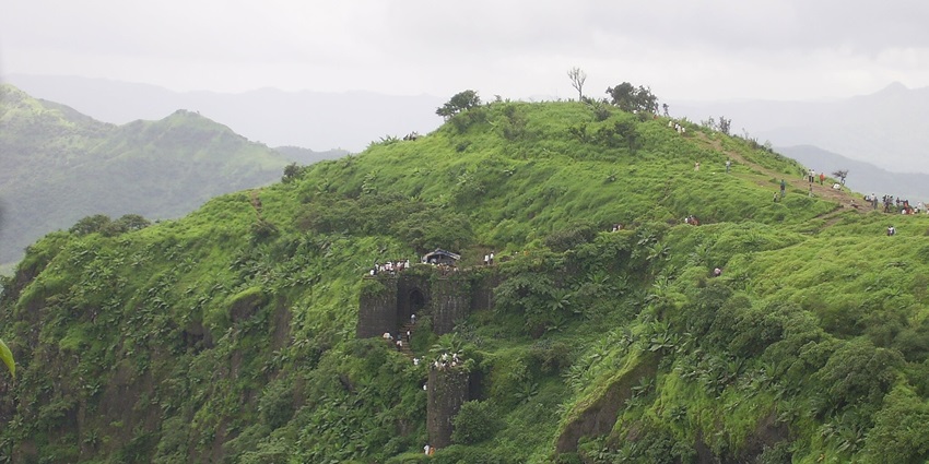 A panoramic view from Fort Sinhagad showcasing lush greenery during monsoon.