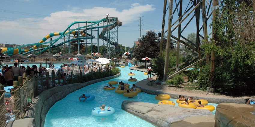 A picture of an adventurous water park with people enjoying the lazy river and wave pool