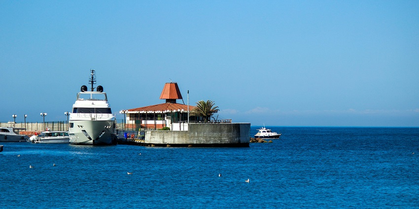 Image of a cruise ship in the harbour around clear blue water and under clear blue sky