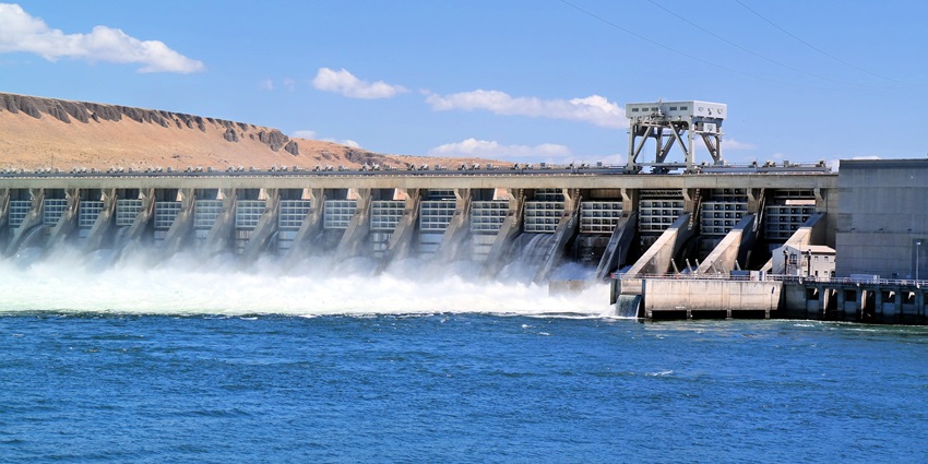 A tranquil view of Gharani Dam with crystal-clear water surrounded by greenery
