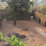 Courtyard of Ghodbunder Fort, showcasing stone walls and greenery.