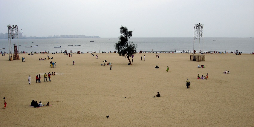Vibrant Chowpatti Beach filled with people enjoying the sun and lively atmosphere.