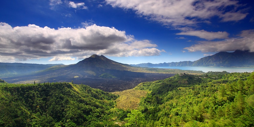 Scenic clouds hover over Mount Batur, and a lake on the right, one of the things to do in Bali.