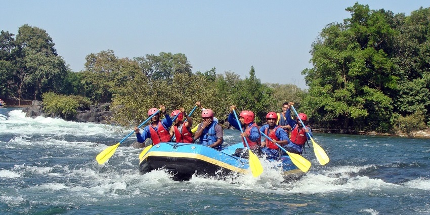 River rafting on the Kali River near Dandeli, surrounded by lush forest and rapids.