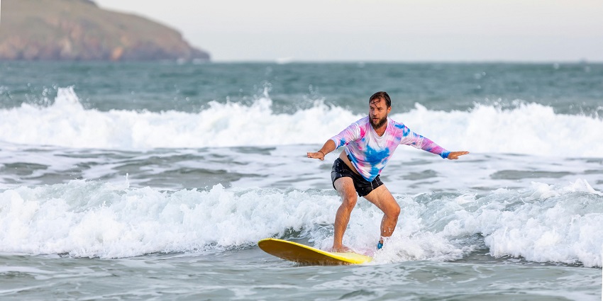 A bearded man surfing and enjoying, one of the best things to do in Seminyak.