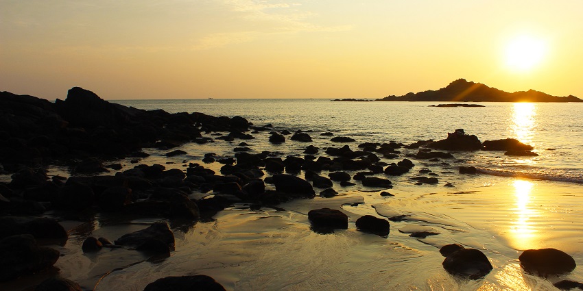 Scenic view of Gokarna's serene beach with vibrant sunset skies, one of the best places to visit in Karnataka in january