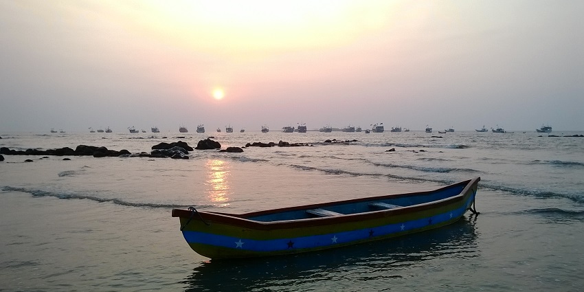 Picturesque view of Gorai Beach and a boat in Mumbai amidst beautiful sunset at the back