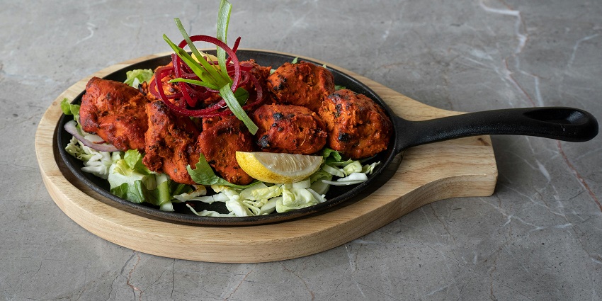 Open-air grill restaurant with a scenic waterfront view.