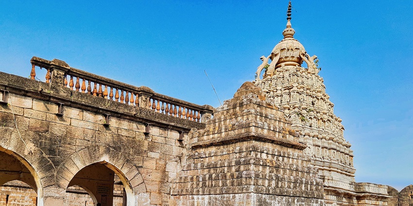 The image displays a tourist attraction near Daulatabad Fort, showcasing an ancient temple.