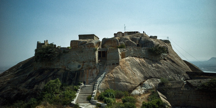 Stone-built Gudibande Fort on a hilltop with panoramic views and historic architecture.