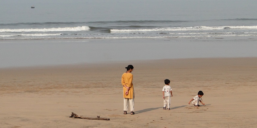Children joyfully collect colourful shells on the sandy shores of Guhagar Beach.