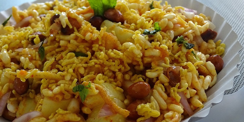 Delicious Bhel Puri made with several ingredients like sev is presented on a paper plate, one of the best food in Bandra.