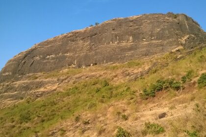 An image showing the Hasdar Fort of Maharashtra amidst the serene hills under clear blue sky.