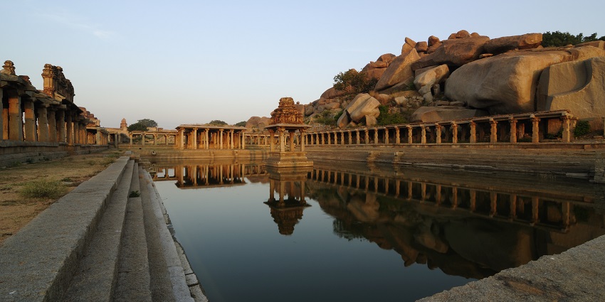 Ancient waters reflecting the glory of Hampi’s ruins.