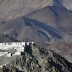 A view of a pristine white spiritual hub nestled in Ladakh surrounded by majestic peaks.