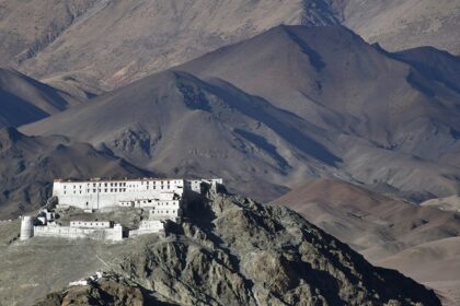 A view of a pristine white spiritual hub nestled in Ladakh surrounded by majestic peaks.