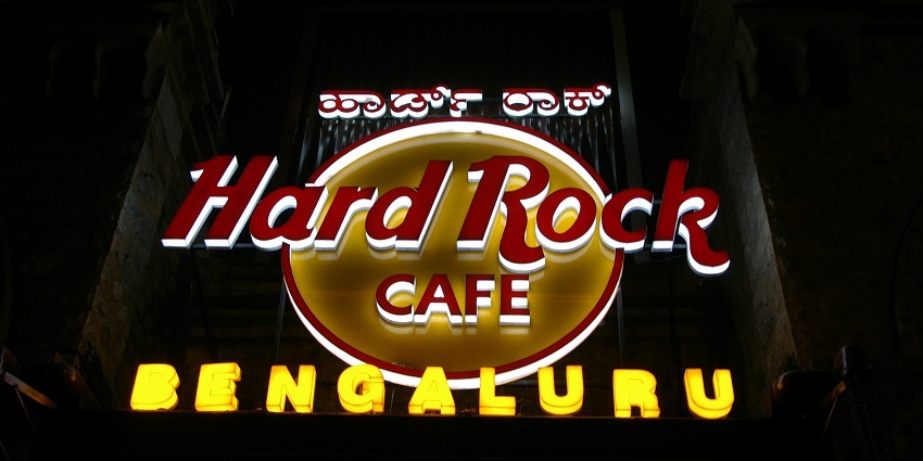 Illuminated Hard Rock Cafe, Bangalore signboard against a vibrant night backdrop.