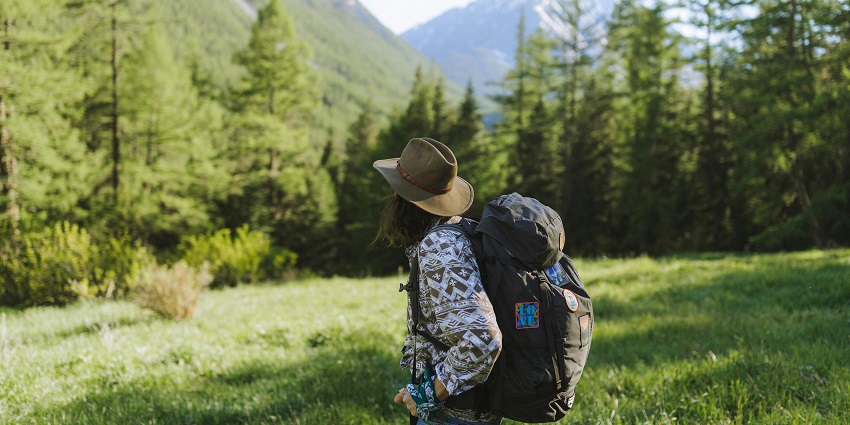 A representative image of a trekker enjoying and adoring the beautiful hills.