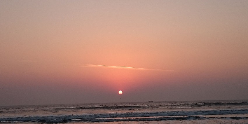 Stunning sunset casting vibrant hues over the serene Harihareshwar Beach landscape.