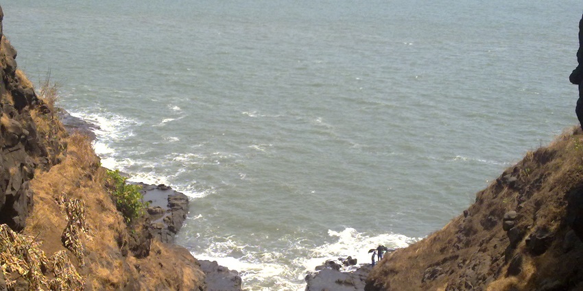 A top view of Harihareshwar beach in Raigad with a calm sea and green hills for peaceful retreat