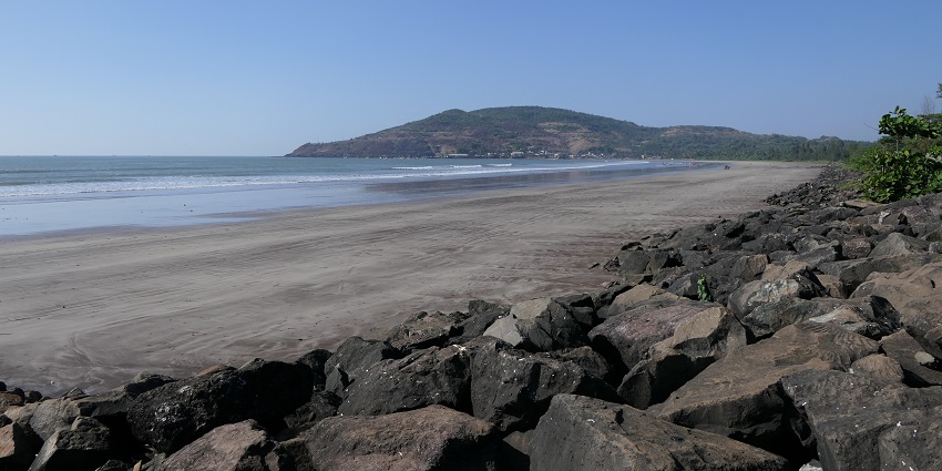 Beautiful view of Harihareshwar Beach featuring its tranquil shoreline and gentle waves.