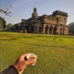 A picture showing a cup of tea along with the iconic Savitribai Phule University in Pune.