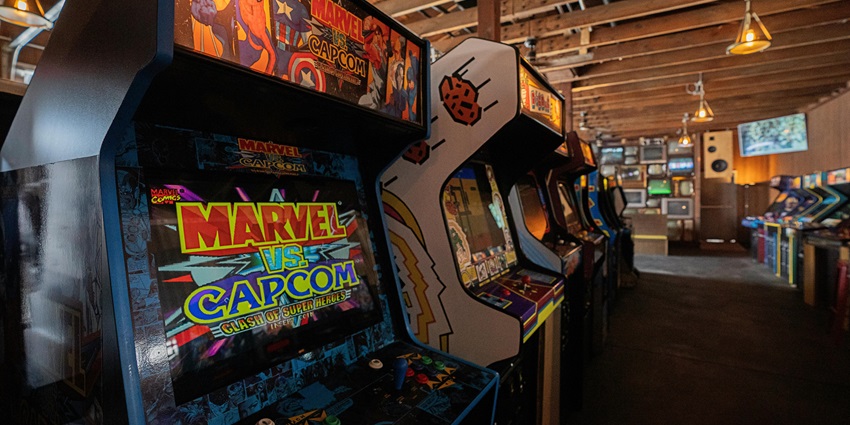 Image of arcade machines with bright, colorful screens in an entertainment club.
