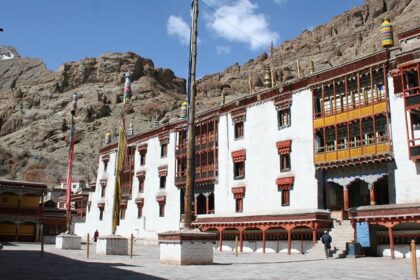 The beautiful exterior of Hemis Monastery during a clear day in Ladakh, surrounded by mountains.