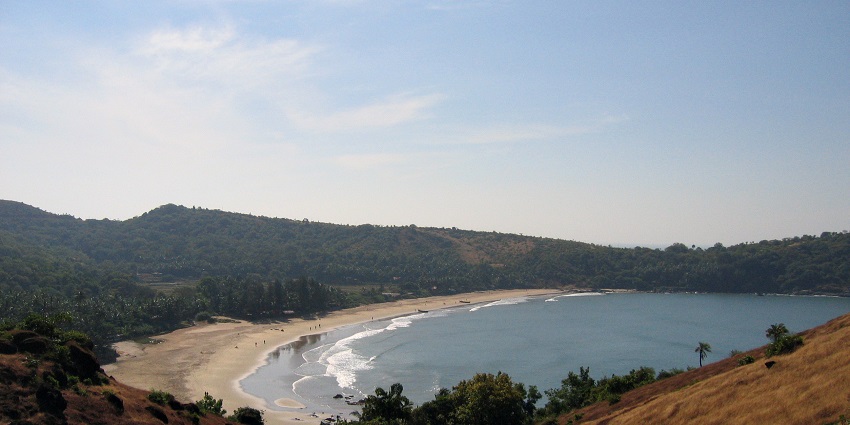 The serene Kudle Beach in Gokarna, surrounded by hills and coconut trees