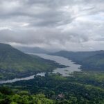 View of Mahabaleshwar, highlighting its rolling hills and vibrant landscape under a clear sky.