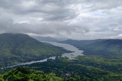 View of Mahabaleshwar, highlighting its rolling hills and vibrant landscape under a clear sky.