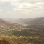 A panoramic view of Panchgani and Mahabaleshwar, featuring hills and valleys under clear skies.