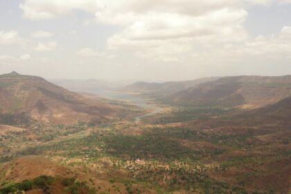 A panoramic view of Panchgani and Mahabaleshwar, featuring hills and valleys under clear skies.