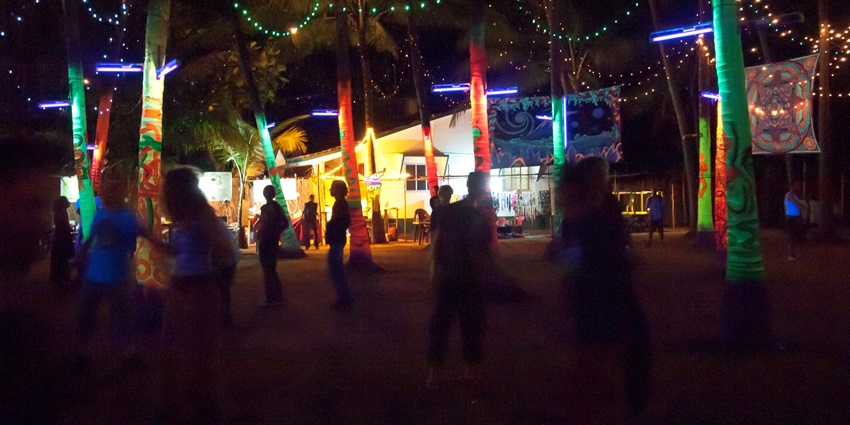 Hilltop decorated with neon lights on the trees at one of the parties in North Goa, India.