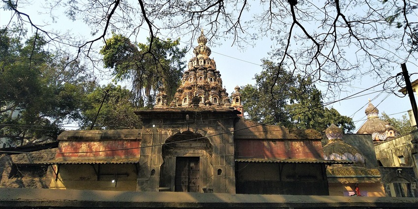 View of the  Hirai Sitai Mandir, surrounded by lush trees ans branches on all sides.
