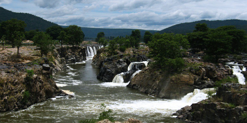 Picturesque view of the Hogenakkal Falls surrounded by large rocks and trees