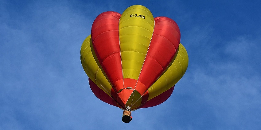 A picture of a colourful hot air balloon floating above the scenic landscapes of Maharashtra.